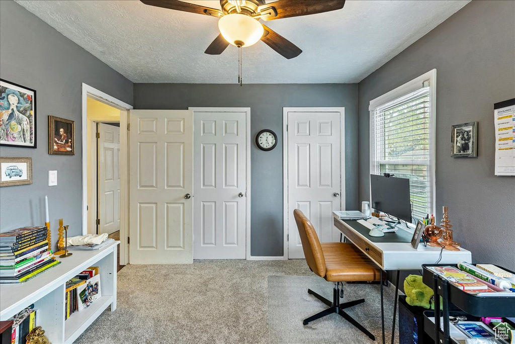 Carpeted home office with ceiling fan and a textured ceiling