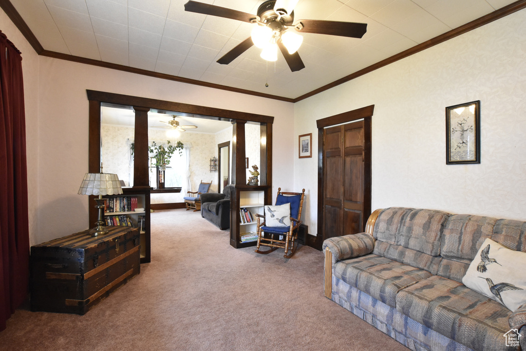 Carpeted living room featuring ornamental molding and ceiling fan
