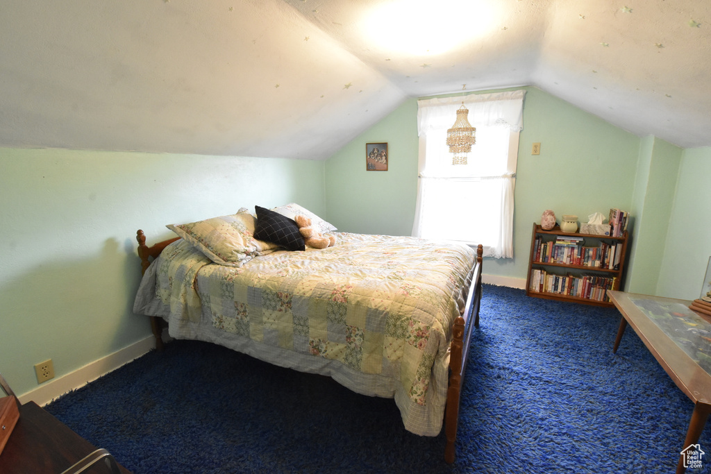 Bedroom with lofted ceiling and carpet