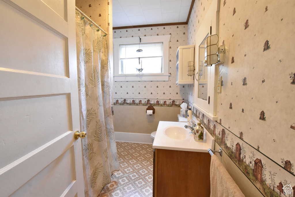 Bathroom featuring ornamental molding, vanity, toilet, and tile flooring