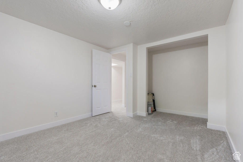 Unfurnished room with carpet flooring and a textured ceiling