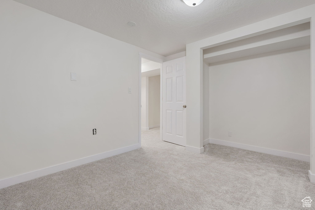 Carpeted empty room featuring a textured ceiling