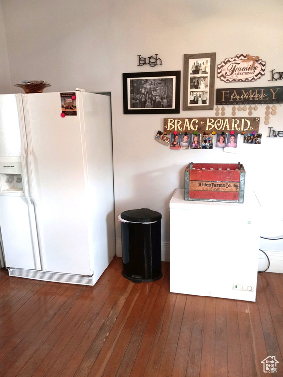 Interior space featuring white refrigerator with ice dispenser and hardwood / wood-style floors