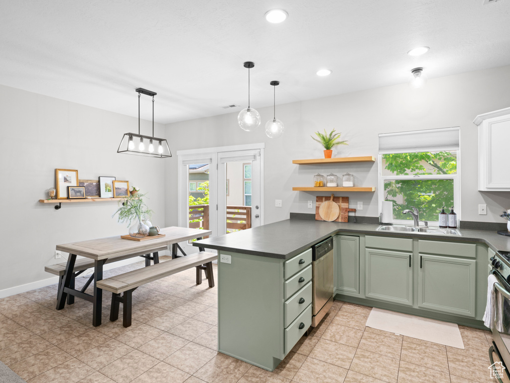 Kitchen featuring sink, plenty of natural light, pendant lighting, and light tile floors