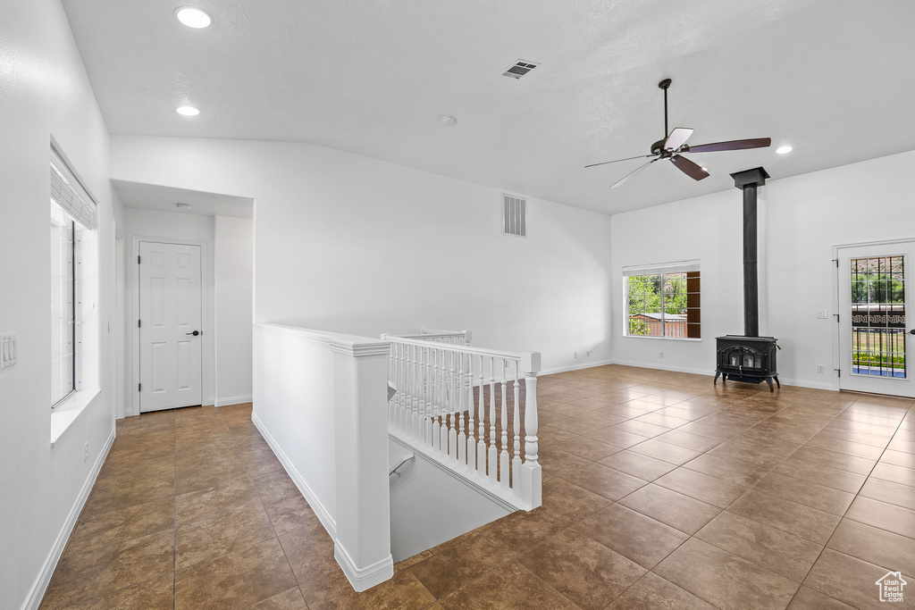 Hall with a wealth of natural light, vaulted ceiling, and tile flooring