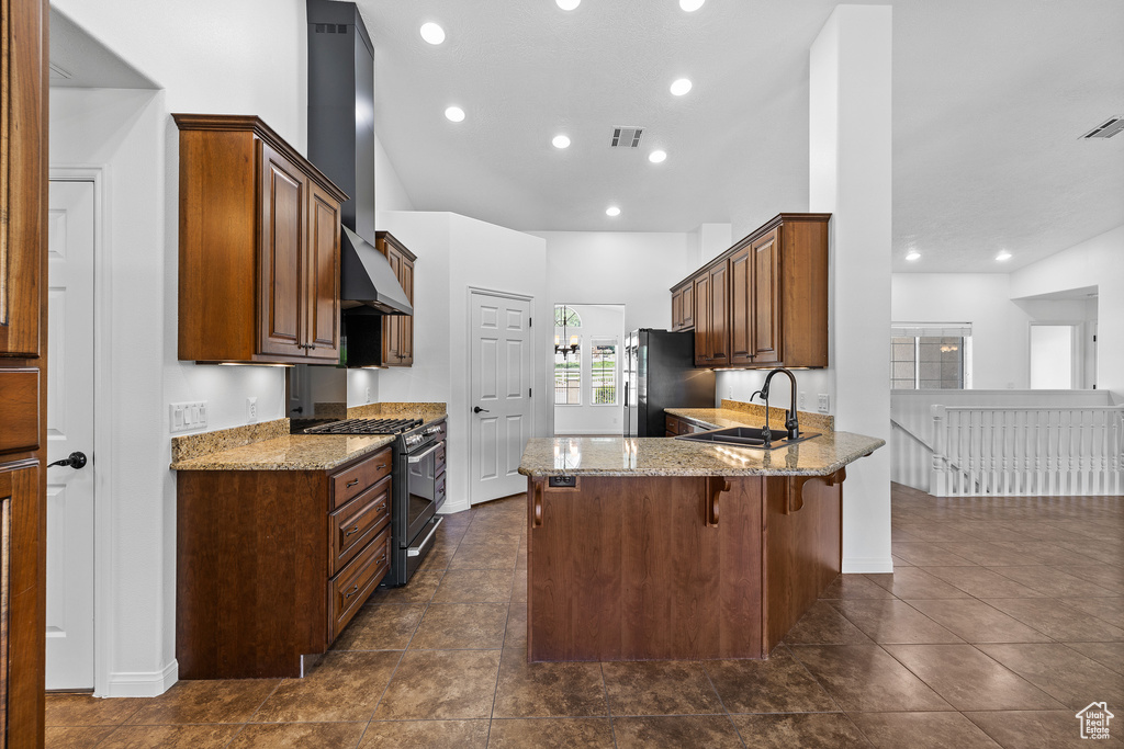 Kitchen featuring high end stainless steel range, sink, and dark tile flooring