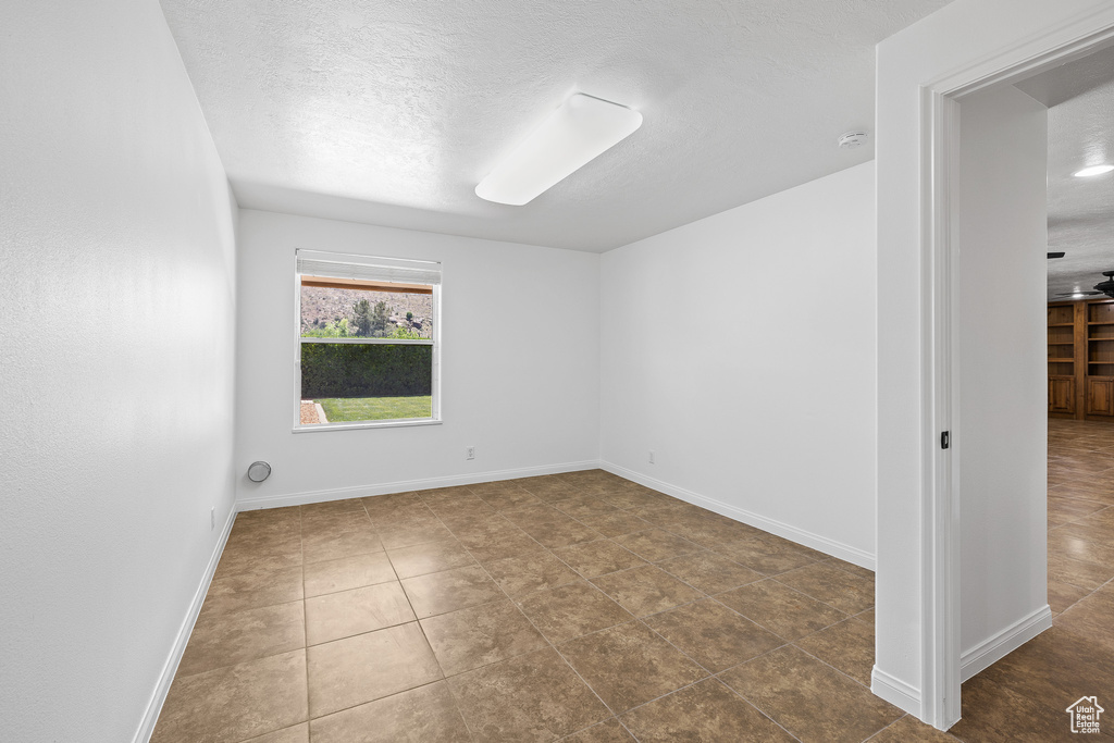 Unfurnished room featuring a textured ceiling and tile floors