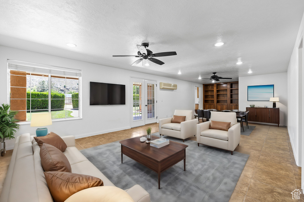 Tiled living room featuring french doors, a wall mounted air conditioner, and ceiling fan