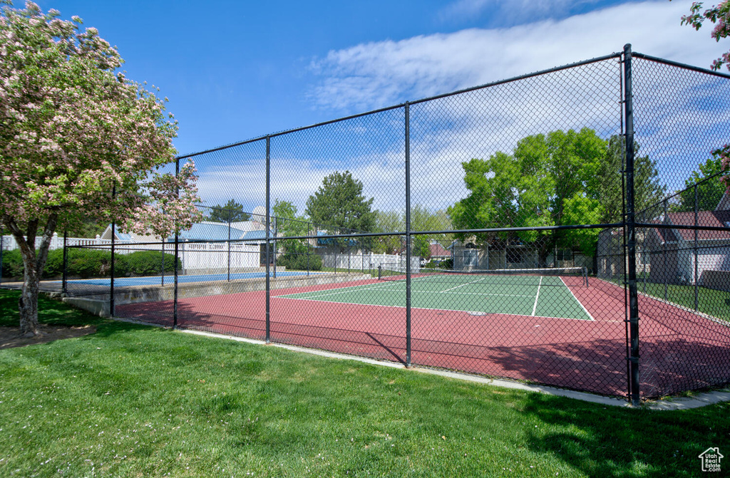View of sport court with a yard