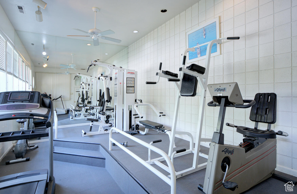 Workout area with tile walls and ceiling fan