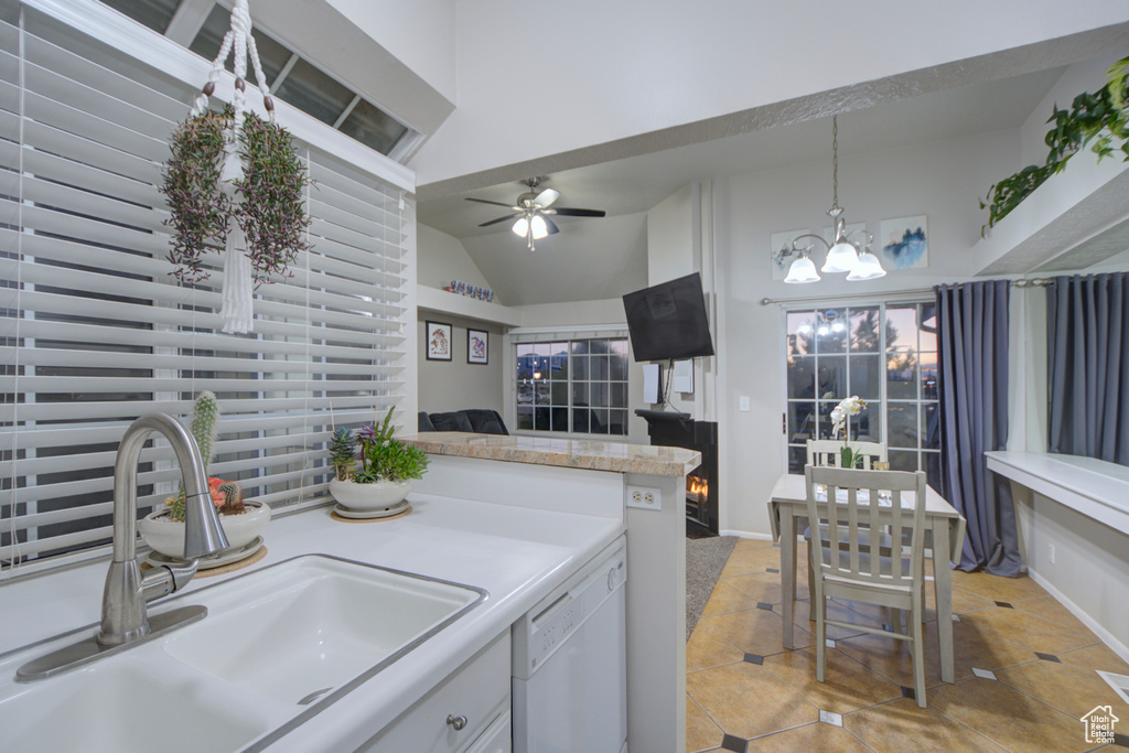 Kitchen featuring pendant lighting, ceiling fan with notable chandelier, white cabinetry, white dishwasher, and sink