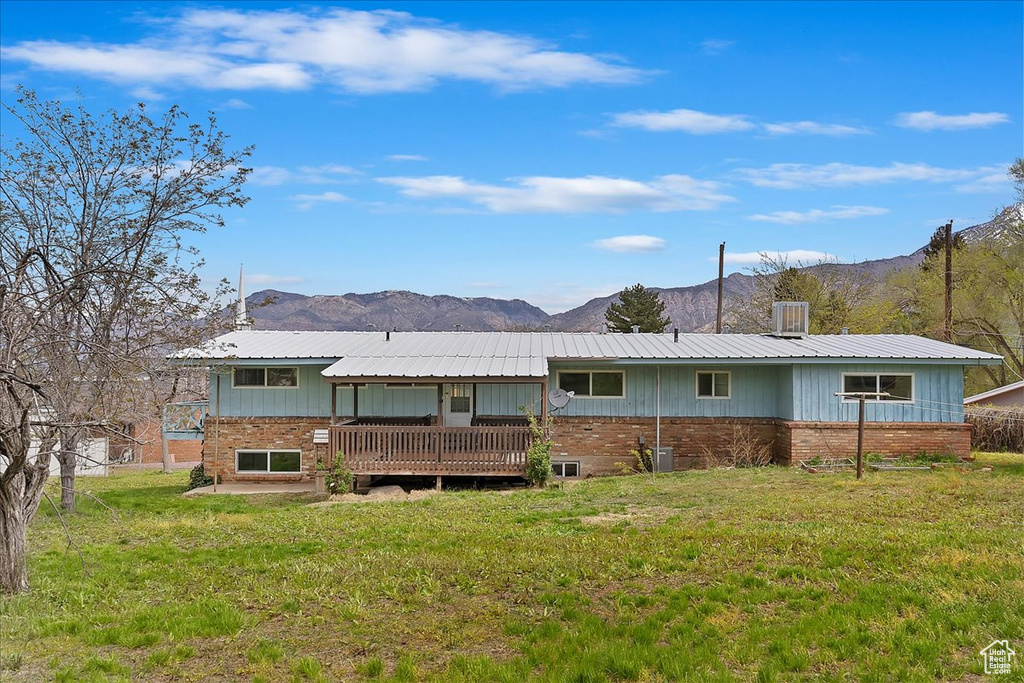 Rear view of property with a yard and a deck with mountain view