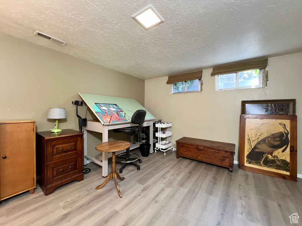 Office space featuring wood-type flooring and a textured ceiling