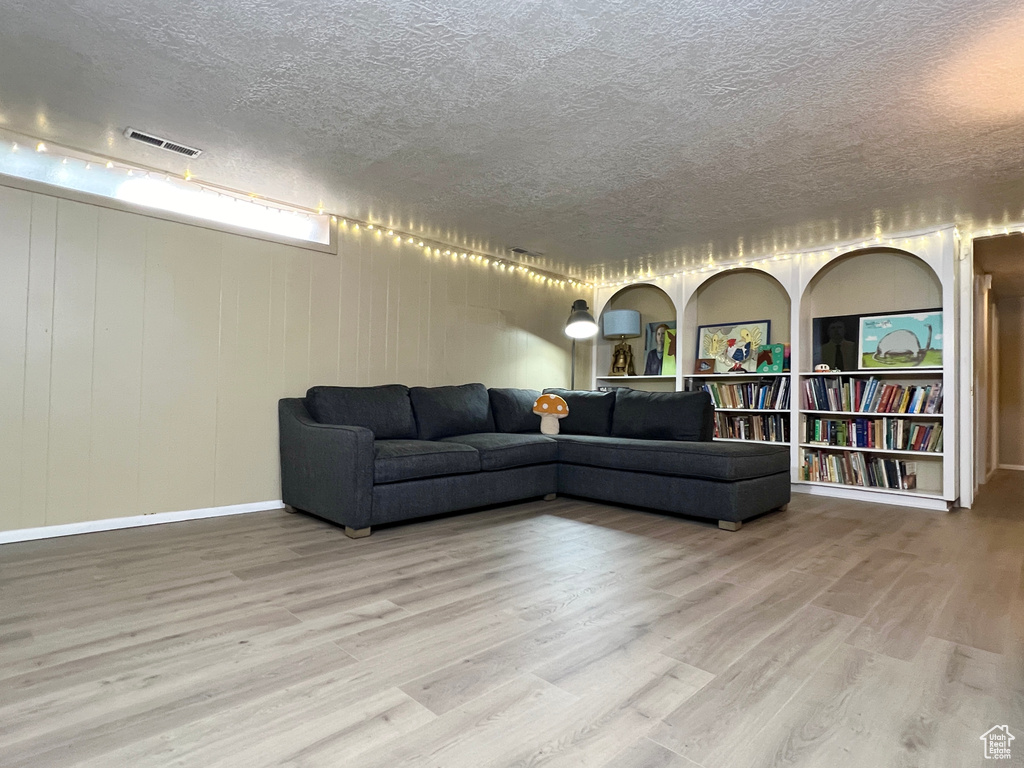 Living room featuring wood-type flooring and a textured ceiling