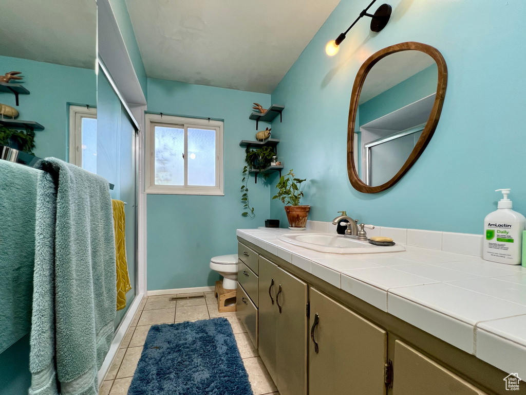 Bathroom with toilet, tile flooring, and vanity