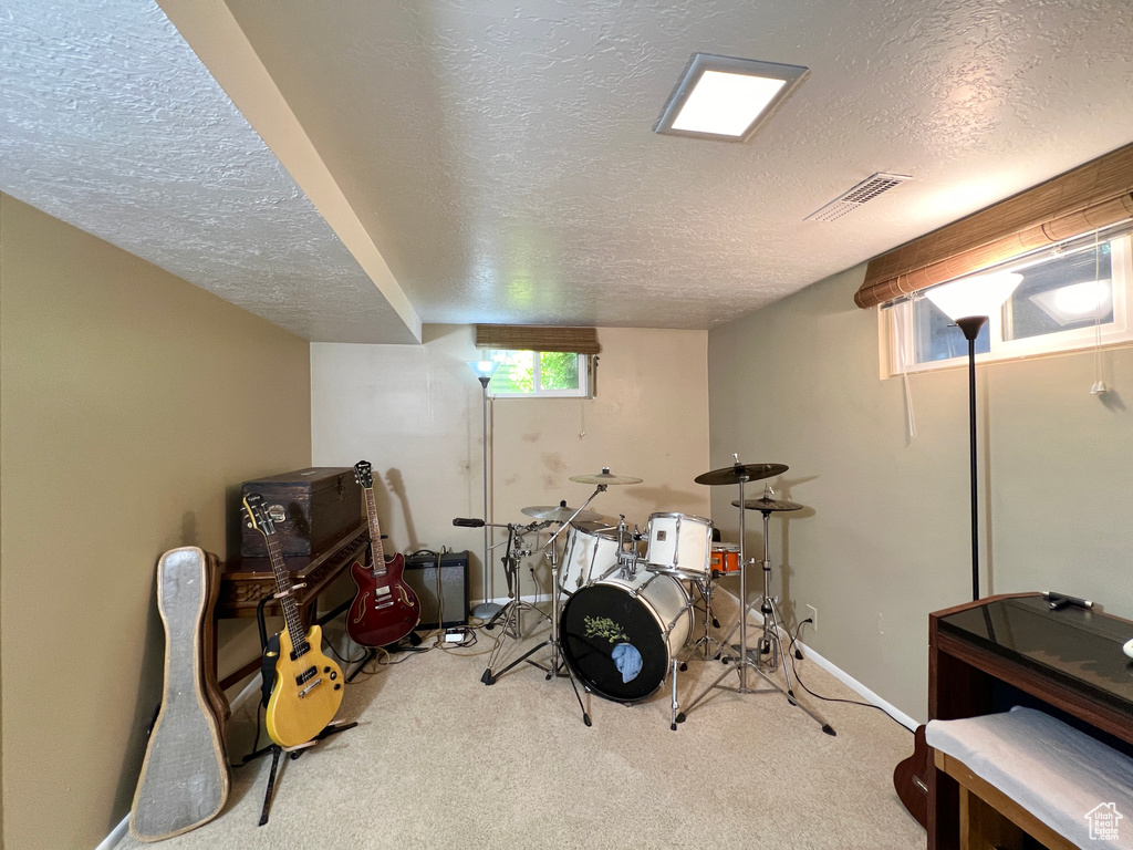 Interior space with a textured ceiling and light carpet