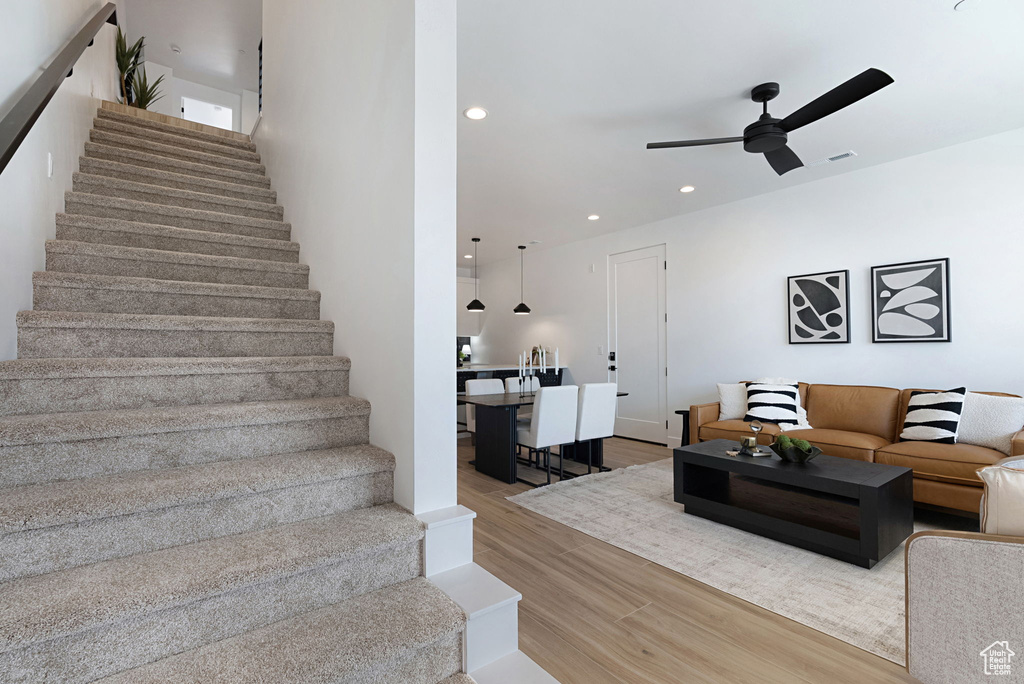 Stairway with wood-type flooring and ceiling fan