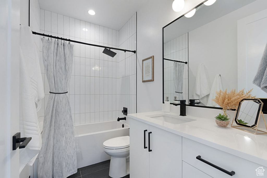 Full bathroom with tile patterned flooring, vanity, toilet, and shower / bath combo with shower curtain