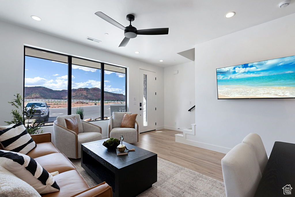 Living room featuring a mountain view, ceiling fan, and light hardwood / wood-style floors