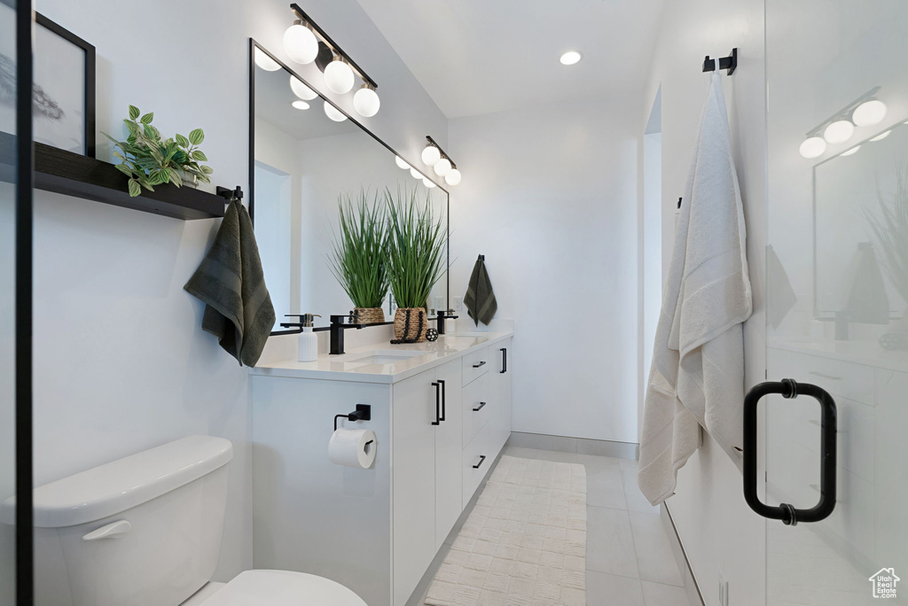 Bathroom with vanity, toilet, and tile patterned flooring