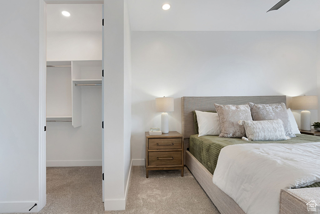 Carpeted bedroom featuring ceiling fan and a closet