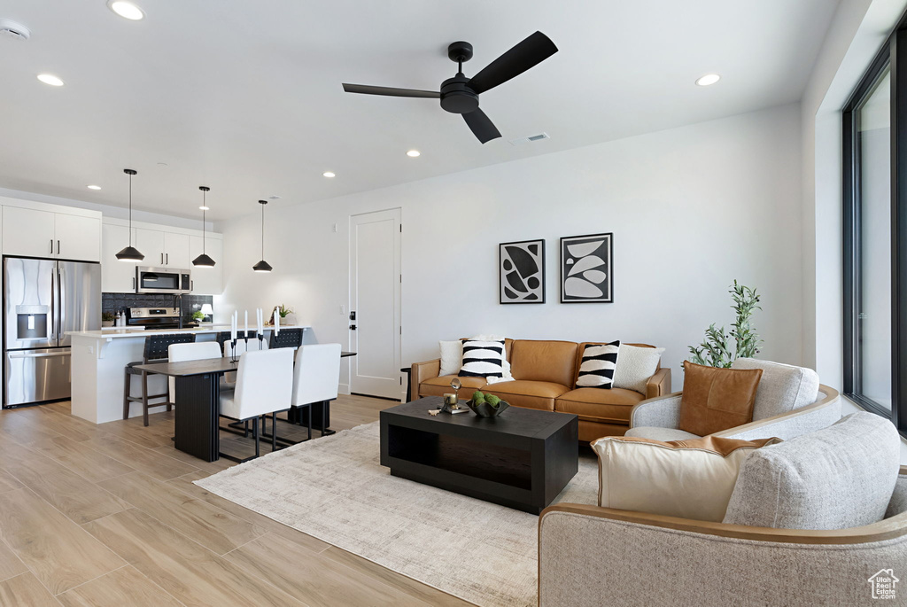 Living room featuring light wood-type flooring and ceiling fan