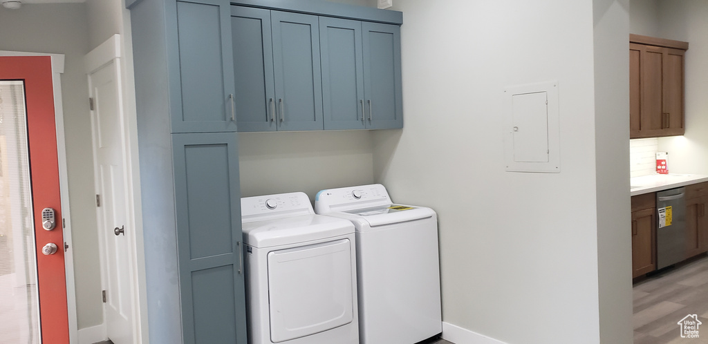 Laundry area with cabinets, hardwood / wood-style flooring, and washer and clothes dryer