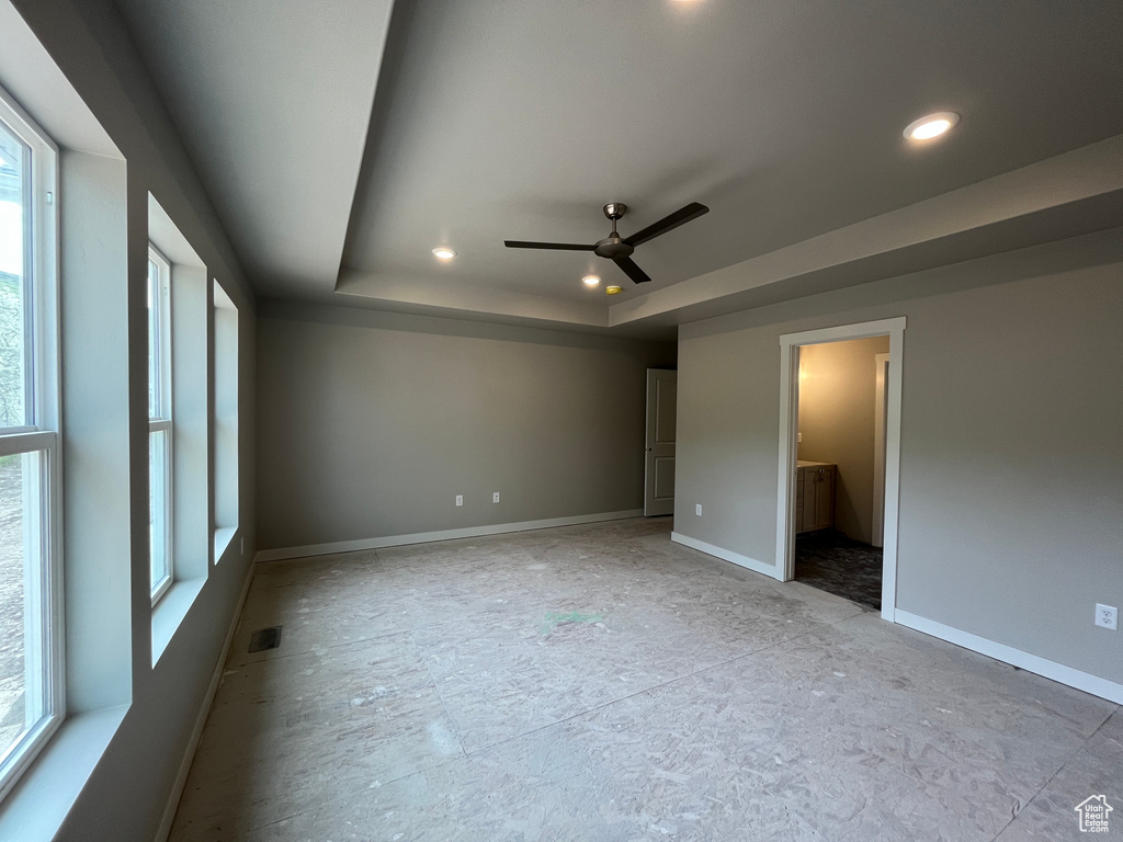 Spare room with a raised ceiling and ceiling fan