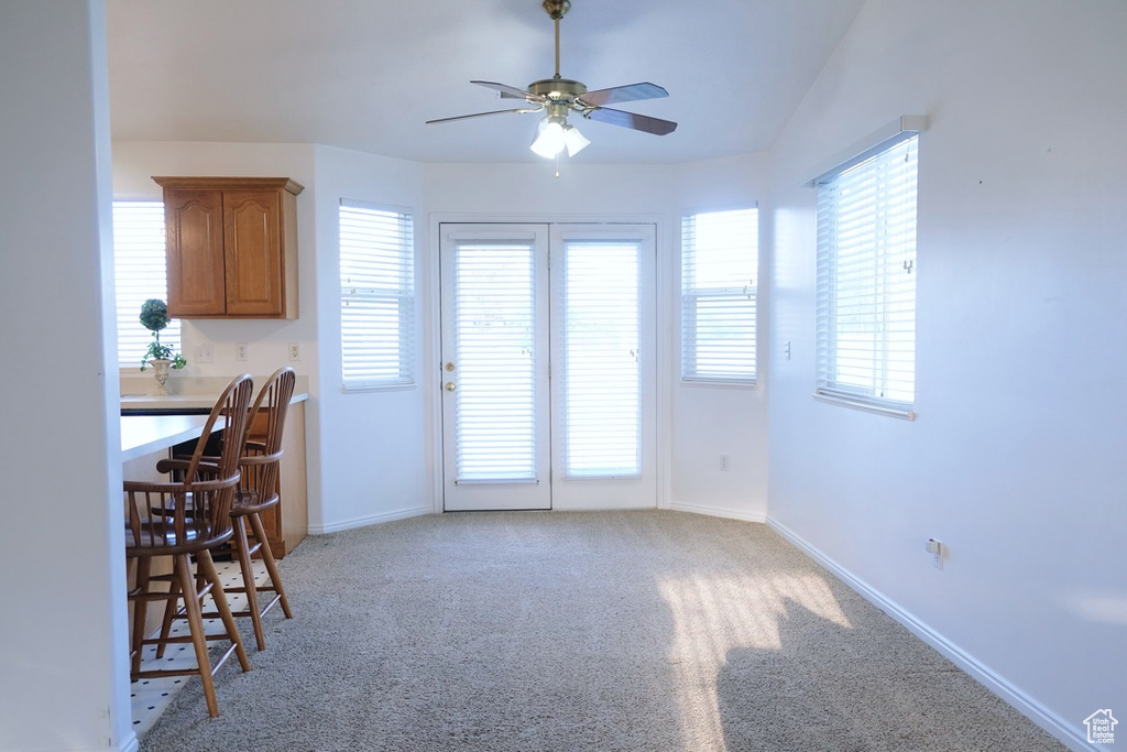 Kitchen featuring plenty of natural light, light colored carpet, and ceiling fan