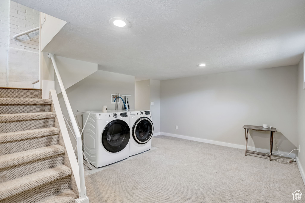 Laundry area with independent washer and dryer, light carpet, and washer hookup