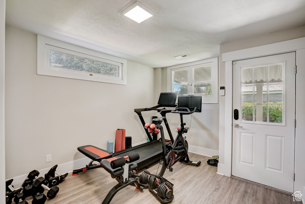 Exercise room featuring light wood-type flooring