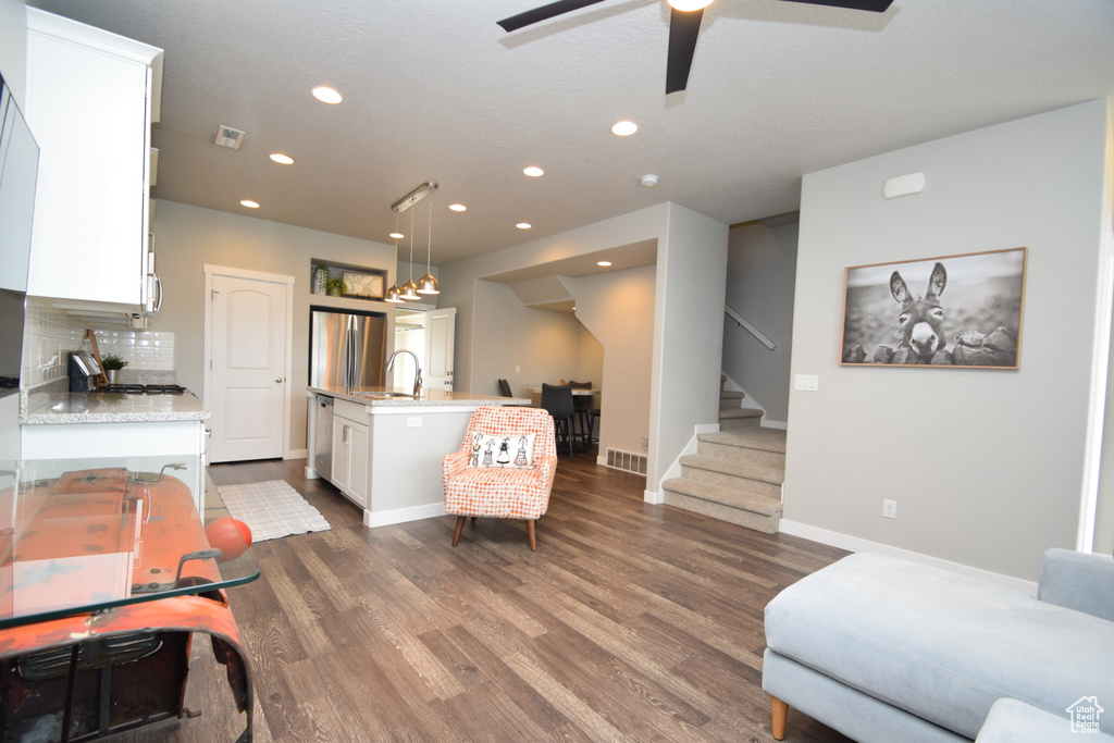 Living room featuring ceiling fan, sink, and dark hardwood / wood-style flooring