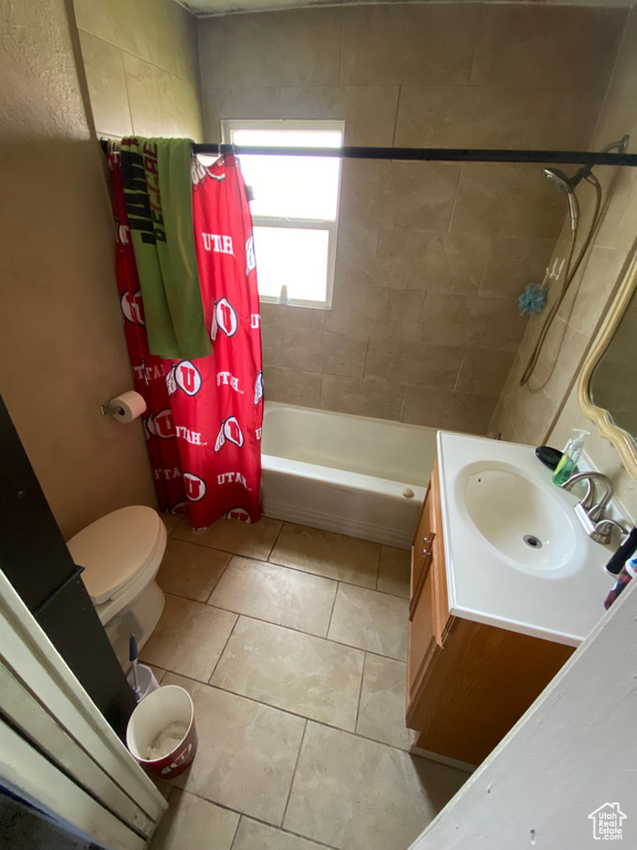 Full bathroom with shower / tub combo with curtain, vanity, toilet, and tile flooring