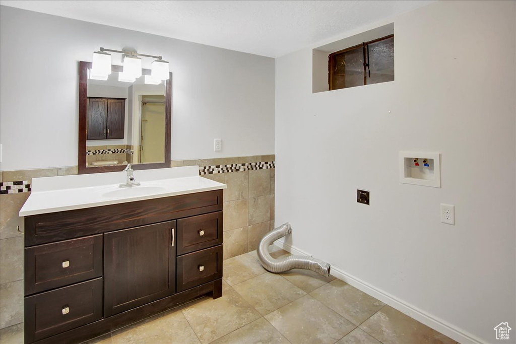 Bathroom featuring tile walls, vanity, and tile floors