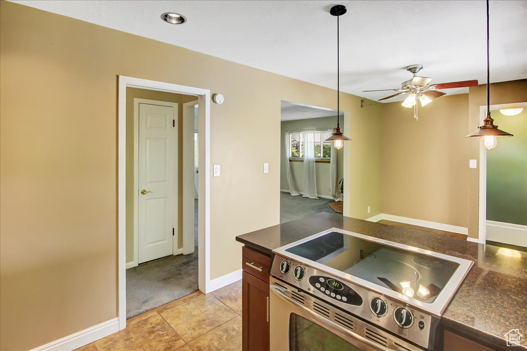 Kitchen featuring hanging light fixtures, ceiling fan, light tile flooring, and stainless steel electric stove