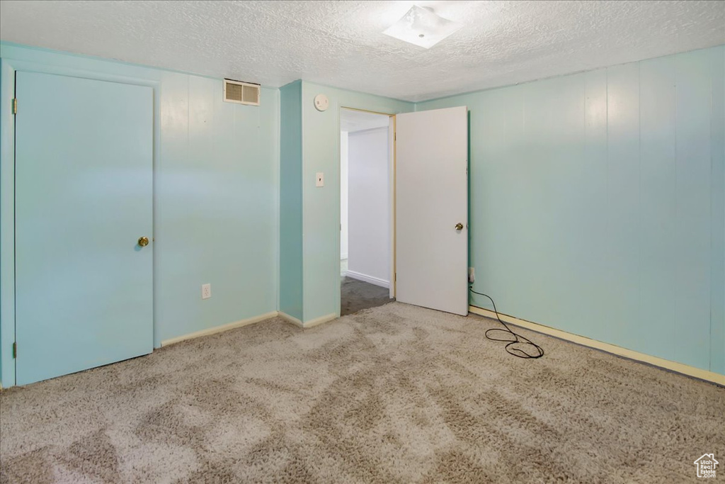 Unfurnished bedroom with carpet flooring, a closet, and a textured ceiling