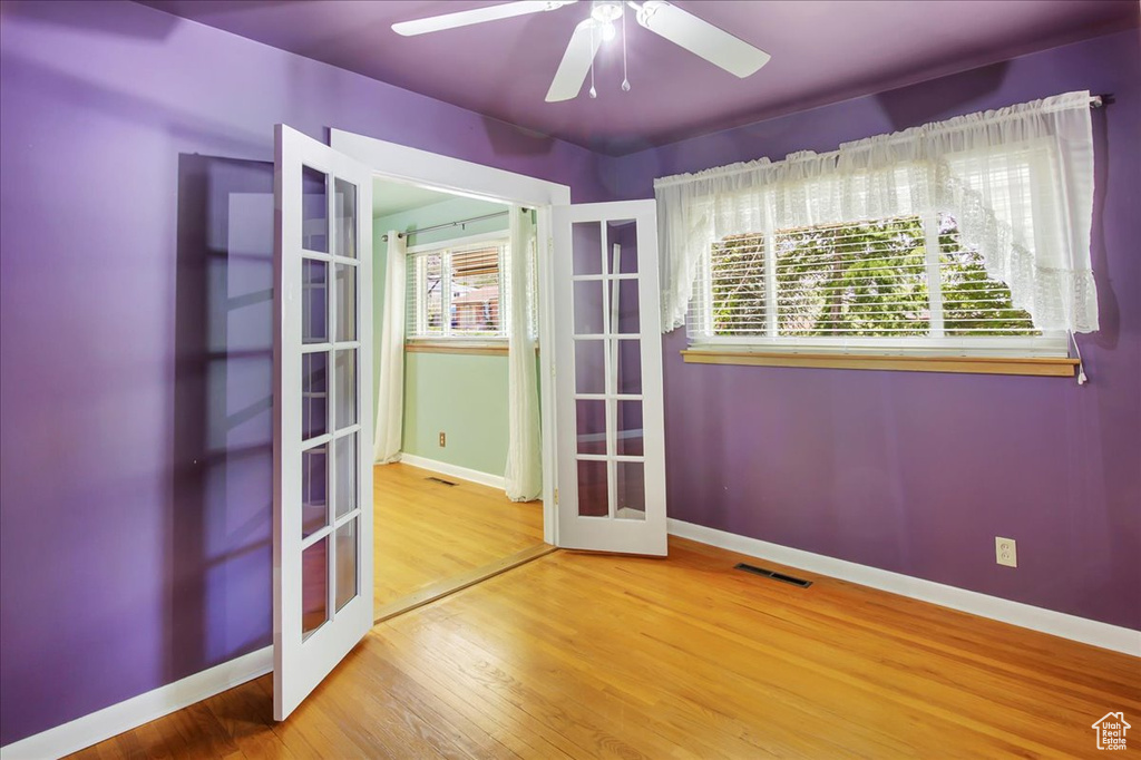 Unfurnished room featuring french doors, ceiling fan, and hardwood / wood-style flooring