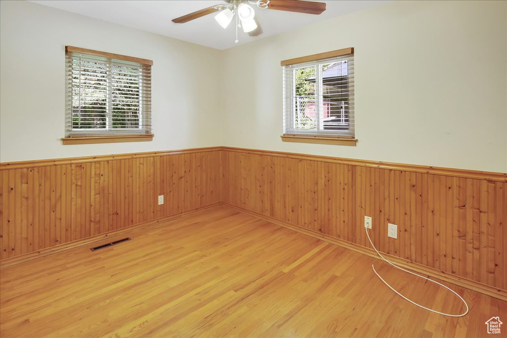 Empty room with ceiling fan and light wood-type flooring
