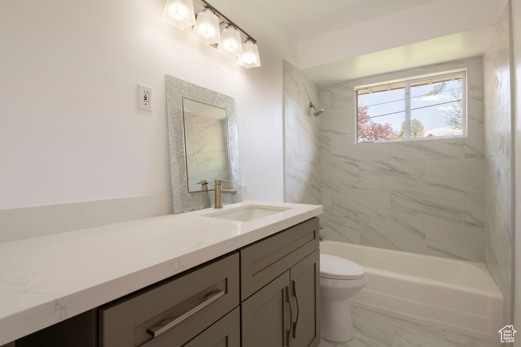Full bathroom featuring tiled shower / bath, toilet, tile flooring, and vanity