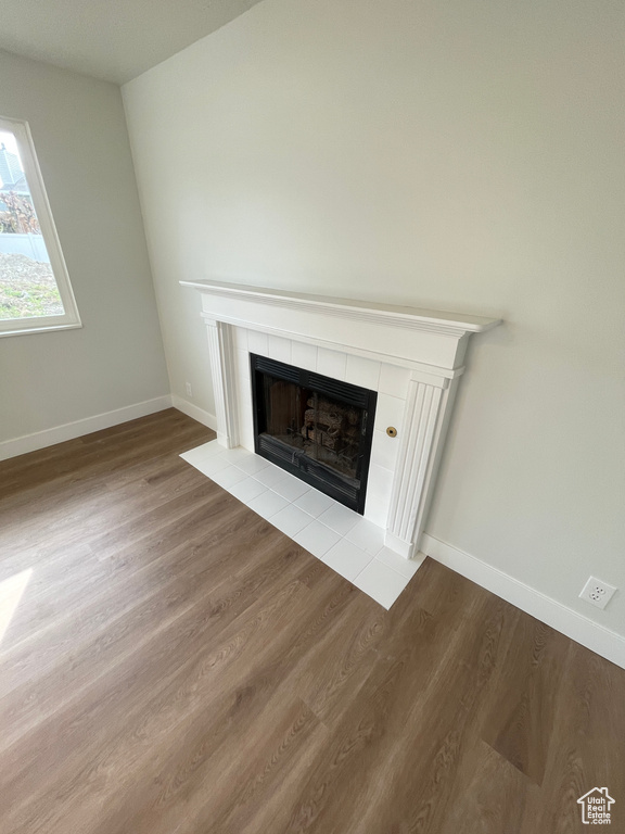 Room details featuring hardwood / wood-style flooring and a tiled fireplace