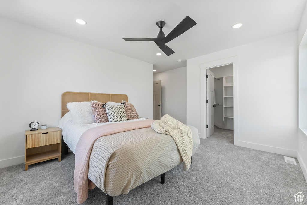 Carpeted bedroom with a closet, a spacious closet, and ceiling fan