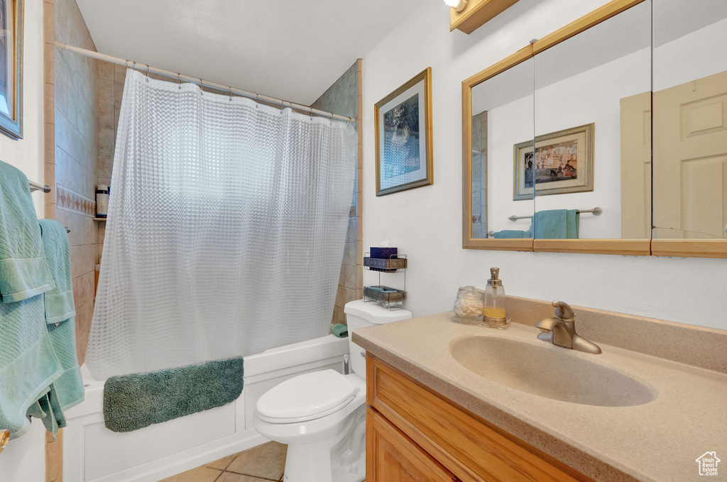 Full bathroom with tile flooring, vanity, toilet, and shower / bathtub combination with curtain