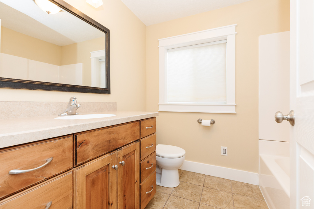 Full bathroom with tile floors, shower / bath combination, vanity, and toilet