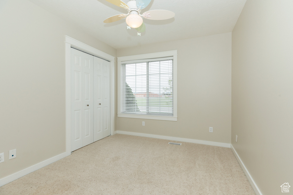 Unfurnished bedroom featuring a closet, ceiling fan, and carpet floors