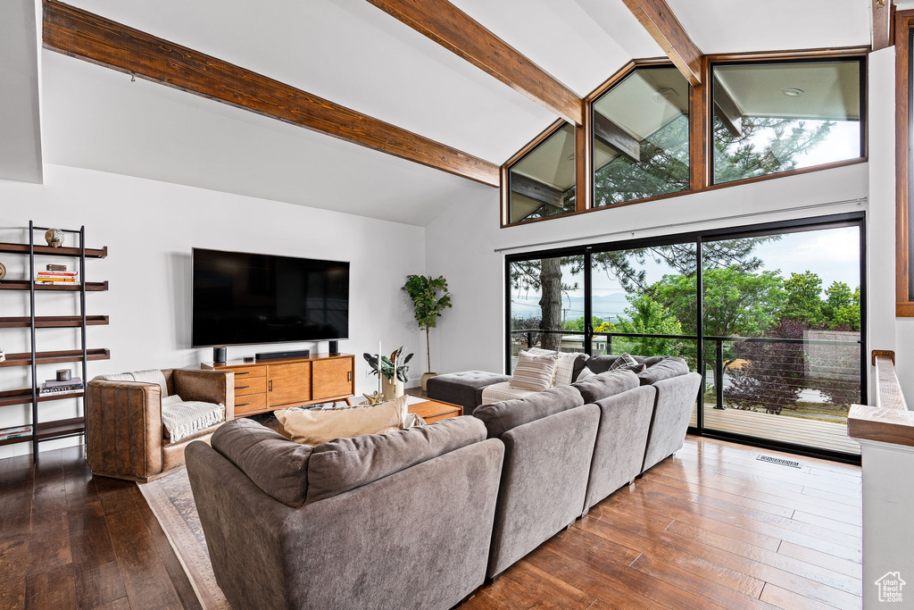 Living room featuring dark hardwood / wood-style flooring and lofted ceiling with beams
