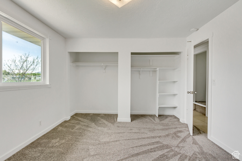 Unfurnished bedroom with carpet floors and two closets