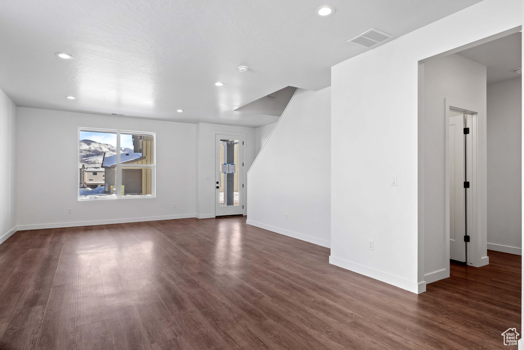 Unfurnished living room featuring dark hardwood / wood-style floors