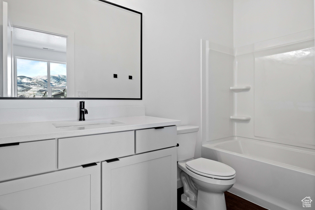 Full bathroom featuring tub / shower combination, vanity with extensive cabinet space, and toilet