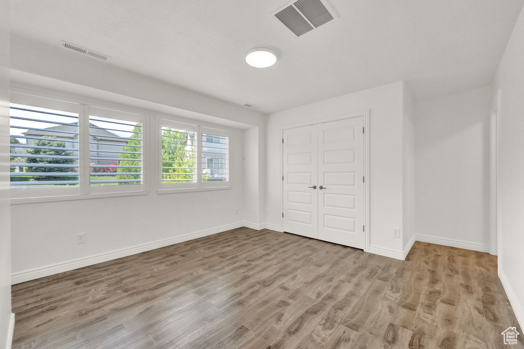 Unfurnished bedroom featuring hardwood / wood-style floors and a closet