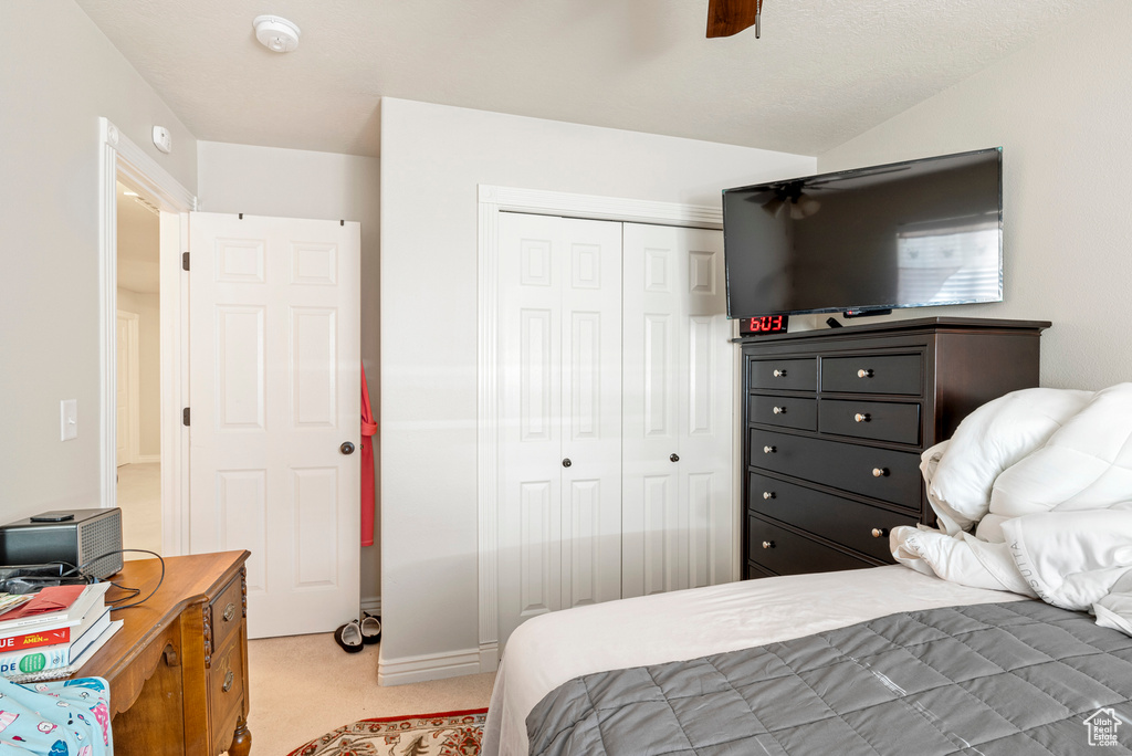 Carpeted bedroom featuring a closet and ceiling fan